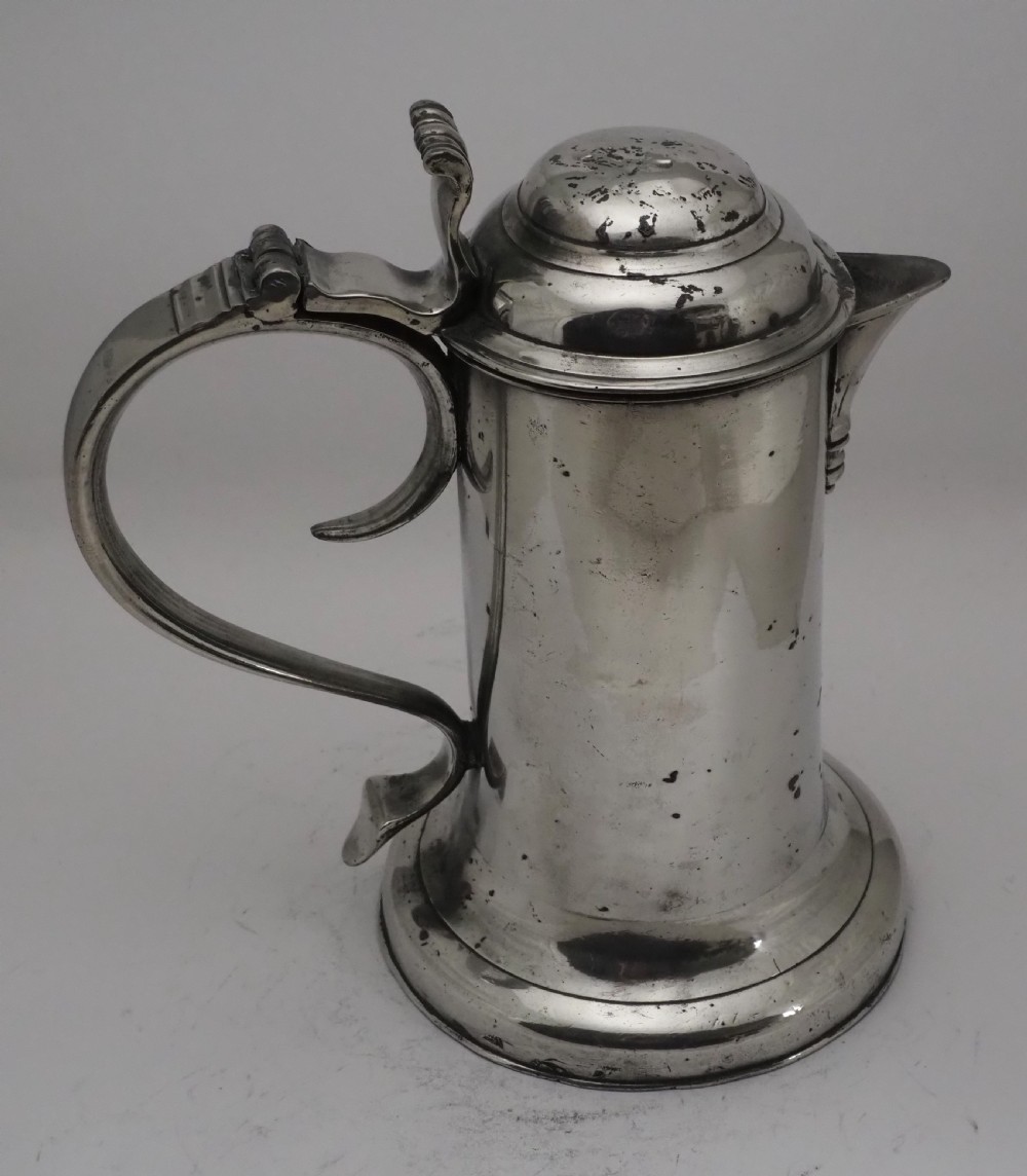 An 18th-century Georgian Irish pewter church flagon featuring a domed hinged lid, double-scroll handle, spout, and circular moulded base. View XI