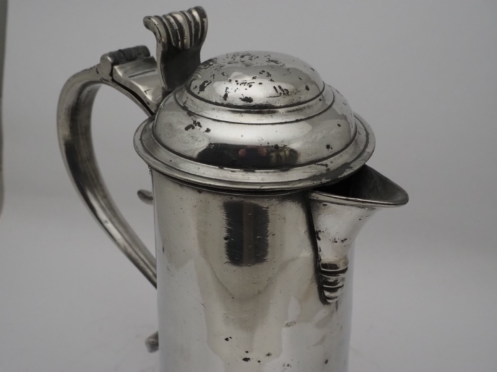 An 18th-century Georgian Irish pewter church flagon featuring a domed hinged lid, double-scroll handle, spout, and circular moulded base. View XII