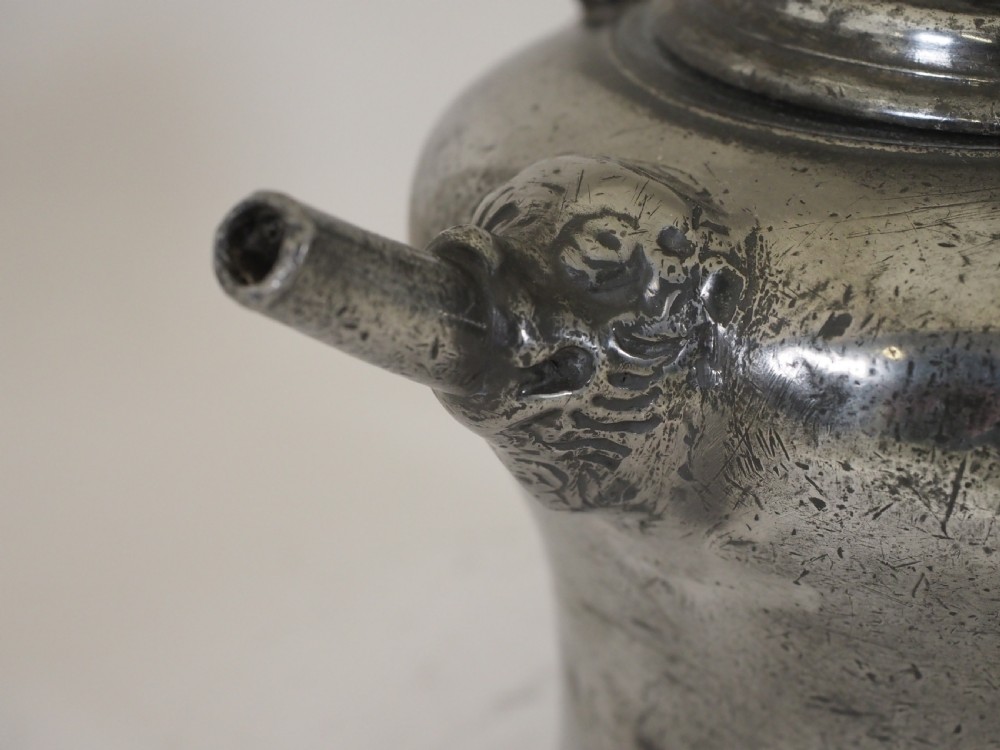 An antique 18th-century Swiss pewter biberon water vessel featuring a flared base, side spout with relief detailing, fitted lid, and tall wire handle. View IV