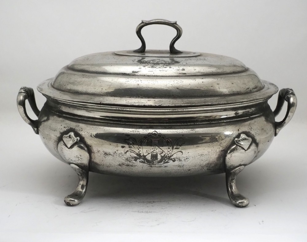 An antique Georgian pewter oval soup tureen featuring a domed lid with a loop handle, twin side handles, cabriole legs, and an engraved armorial crest. View II