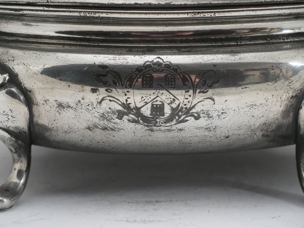 An antique Georgian pewter oval soup tureen featuring a domed lid with a loop handle, twin side handles, cabriole legs, and an engraved armorial crest. View III