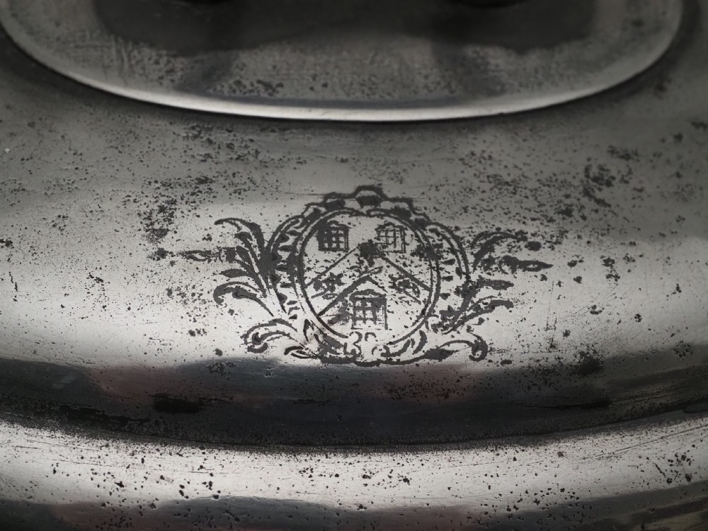An antique Georgian pewter oval soup tureen featuring a domed lid with a loop handle, twin side handles, cabriole legs, and an engraved armorial crest. View VI