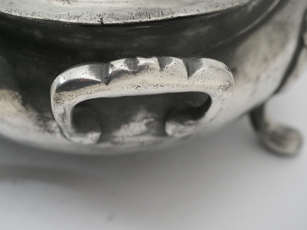 An antique Georgian pewter oval soup tureen featuring a domed lid with a loop handle, twin side handles, cabriole legs, and an engraved armorial crest. View IX