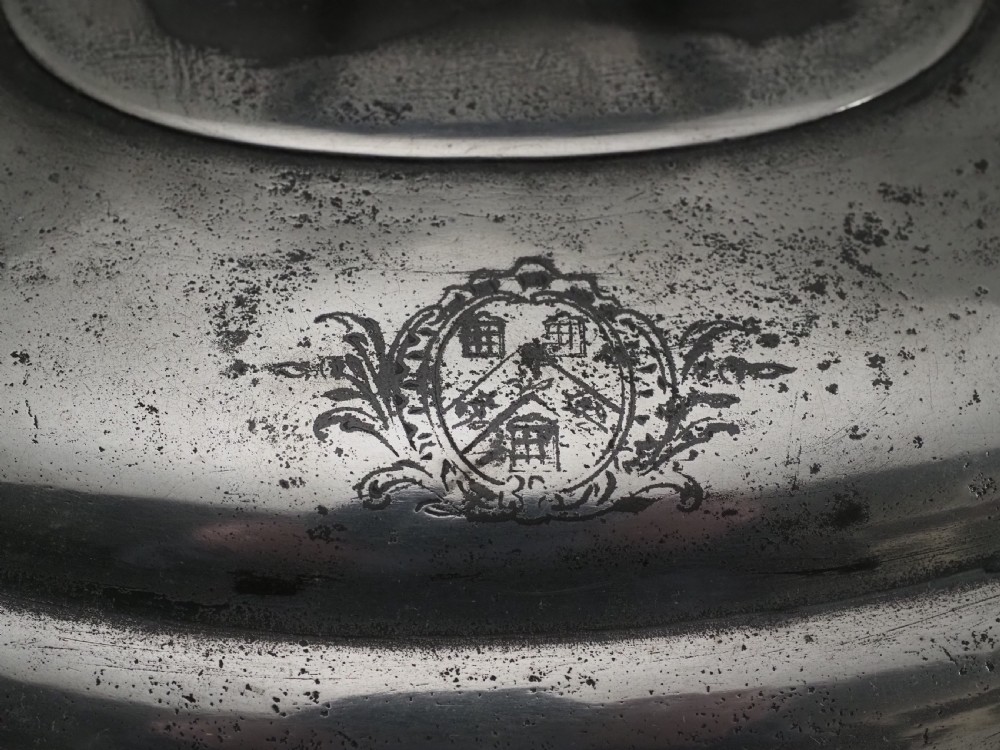 An antique Georgian pewter oval soup tureen featuring a domed lid with a loop handle, twin side handles, cabriole legs, and an engraved armorial crest. View XV