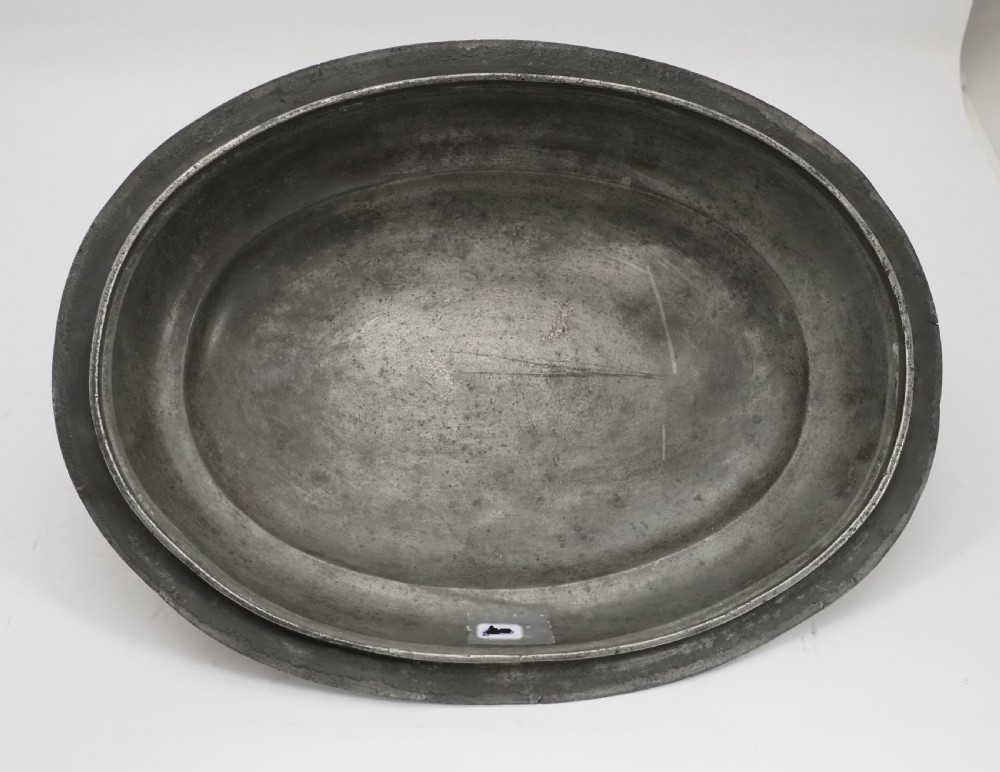 An antique Georgian pewter oval soup tureen featuring a domed lid with a loop handle, twin side handles, cabriole legs, and an engraved armorial crest. View XVI
