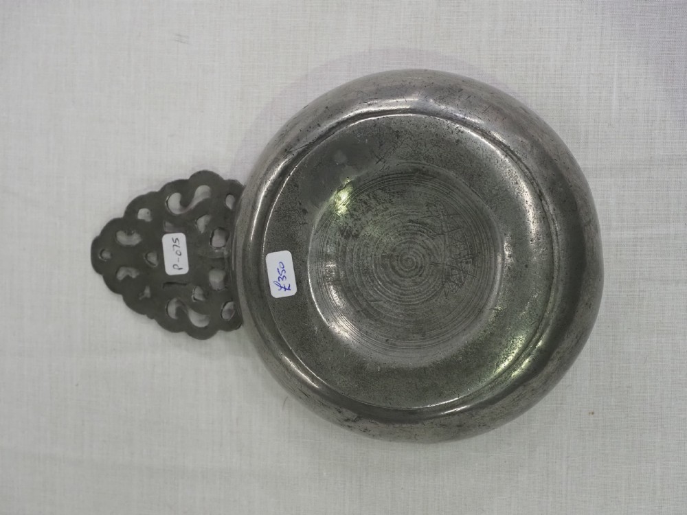 An antique silver-grey pewter porringer bowl featuring a single ornate pierced scrollwork ear handle. View VI