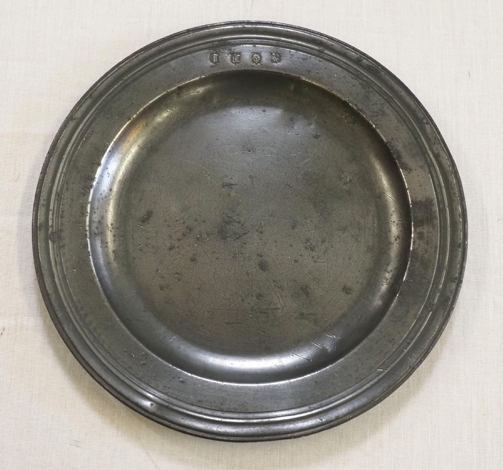 A circular antique pewter plate with a triple reeded rim and stamped touchmarks along the upper border. View II