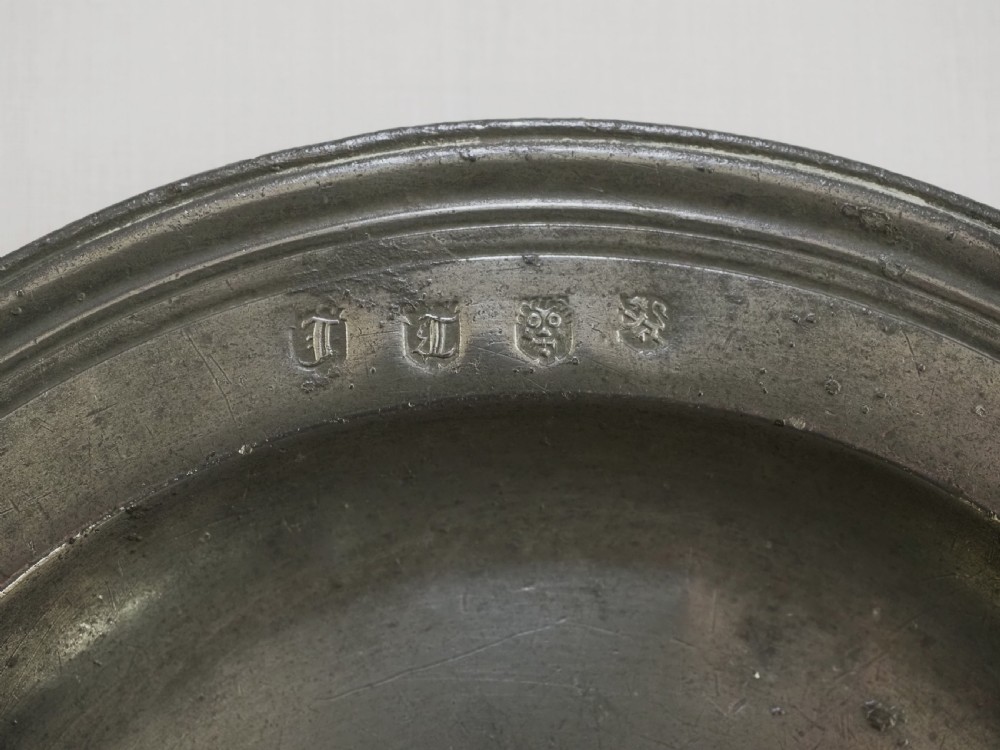 A circular antique pewter plate with a triple reeded rim and stamped touchmarks along the upper border. View III