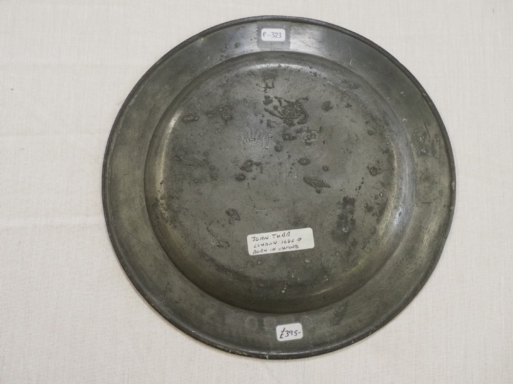 A circular antique pewter plate with a triple reeded rim and stamped touchmarks along the upper border. View IV