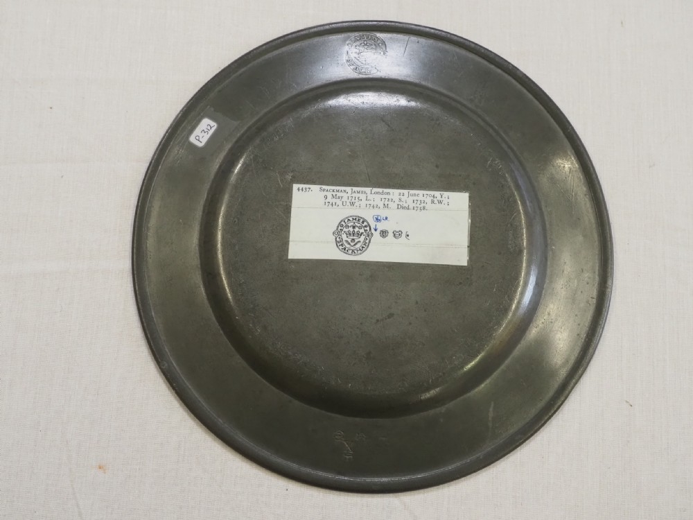 An 18th-century circular English pewter plate with a wide plain rim featuring an engraved lion crest at the top. View IV