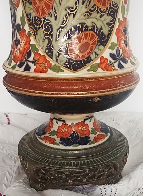 fig 2. A Victorian ceramic oil lamp featuring an etched pink glass shade, brass Duplex burner mechanism, and hand-painted floral ceramic body on a metal base.
