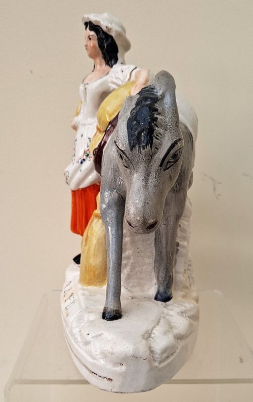 fig 2. A pair of Victorian Staffordshire earthenware pottery figures depicting street traders named Sand and Beesums standing beside saddled grey donkeys.