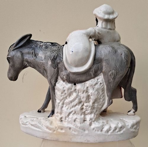 fig 3. A pair of Victorian Staffordshire earthenware pottery figures depicting street traders named Sand and Beesums standing beside saddled grey donkeys.