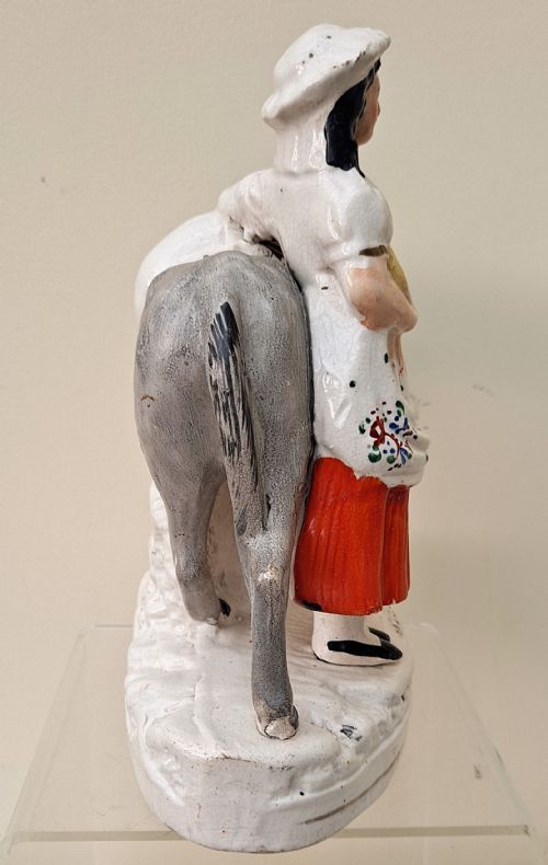 fig 4. A pair of Victorian Staffordshire earthenware pottery figures depicting street traders named Sand and Beesums standing beside saddled grey donkeys.