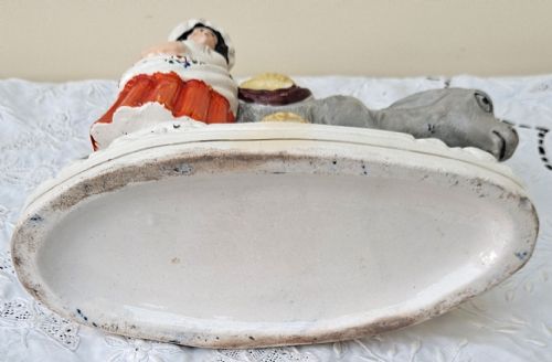 fig 5. A pair of Victorian Staffordshire earthenware pottery figures depicting street traders named Sand and Beesums standing beside saddled grey donkeys.
