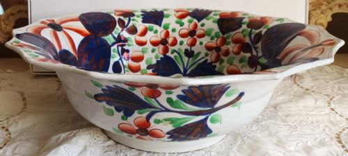 fig 1. An octagonal Victorian ceramic wash basin painted with red and green floral motifs, cobalt blue leaves, and metallic copper lustre accents on a white earthenware base.