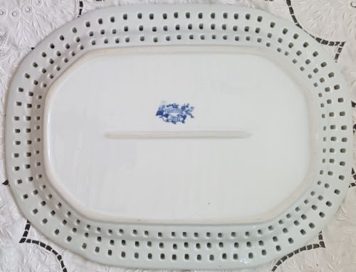 fig 1. An oval blue and white earthenware platter featuring a reticulated pierced border and a detailed Chinoiserie transfer pattern with a central net motif.