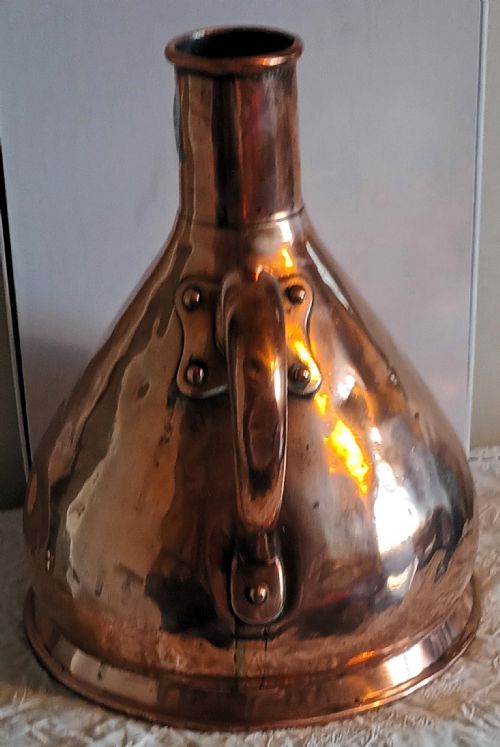 fig 1. A Georgian copper one-gallon haystack measure with a conical body, narrow neck, broad strap handle, and a lead verification seal.