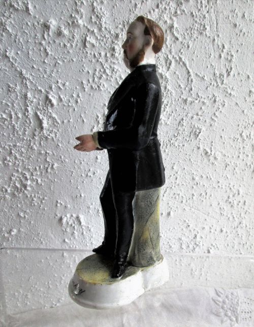fig 1. An antique Victorian porcelain figurine depicting a standing man in a black frock coat and bow tie on a round white base inscribed Mr Sankey.