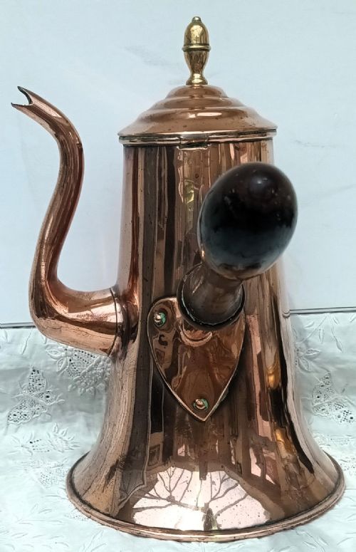 fig 1. An antique Georgian copper coffee pot featuring a tapered body, a curved gooseneck spout, a top brass finial, and a turned wooden side handle.