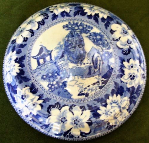 fig 1. An antique blue and white transfer-printed earthenware tureen featuring a pedestal base, floral patterns, and a fitted lid with a molded animal finial.