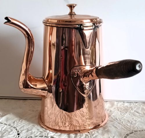 fig 1. A Georgian copper coffee pot featuring a tapered body, a curved spout, a hinged lid with finial, and a turned wooden side handle.