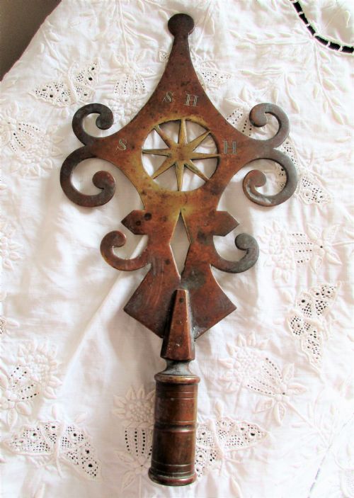 fig 1. An antique Victorian cast brass friendly society pole head featuring a central star motif within a circular cut-out surrounded by pierced scrollwork and a hollow mounting socket at the base.
