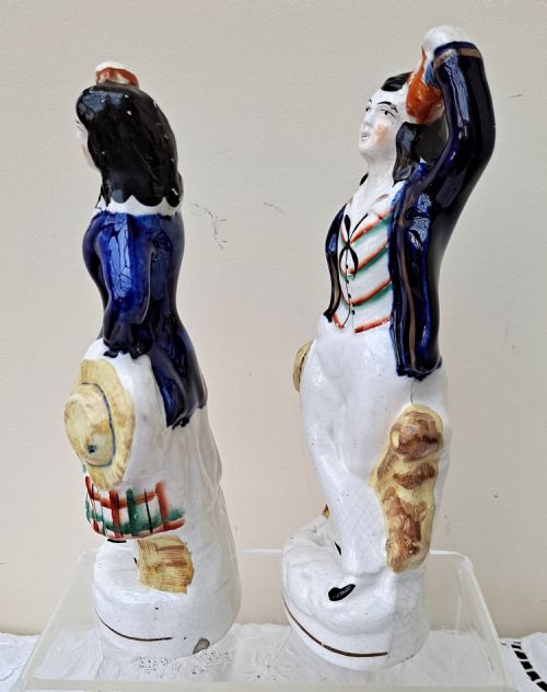 fig 1. A pair of Victorian Staffordshire earthenware figures depicting a male sailor and a female companion wearing cobalt blue jackets.