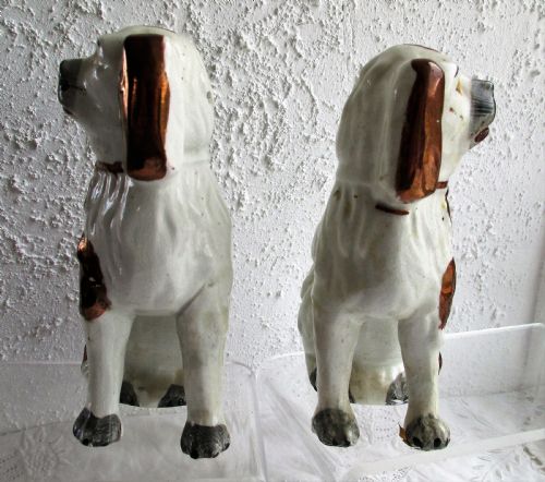 fig 1. A pair of seated antique Victorian Staffordshire pottery spaniel dog figurines with white glazed bodies and painted copper lustre spots.