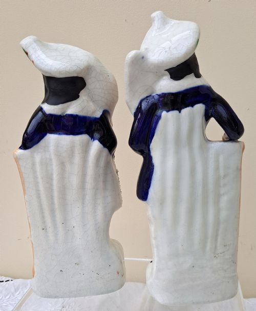 fig 2. A pair of antique Victorian Staffordshire earthenware figures depicting a male and female gardener dressed in colourful attire holding flowers.