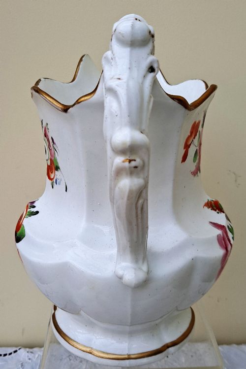 fig 1. A white early Victorian porcelain jug decorated with hand-painted floral sprays and a gilded rim and handle.