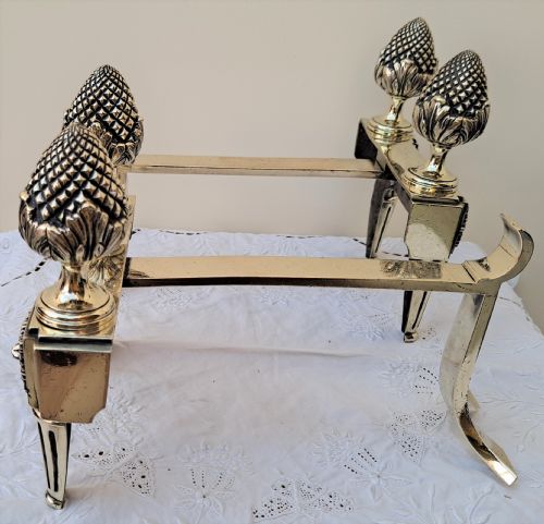 fig 1. A pair of Georgian brass firedogs featuring detailed pineapple finials and tapered fluted feet.
