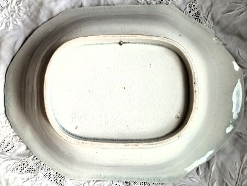 fig 1. An oval Victorian glazed earthenware dish featuring a central transfer-printed portrait titled Dr Livingstone surrounded by painted floral garlands, flags, and a purple rope border pattern.