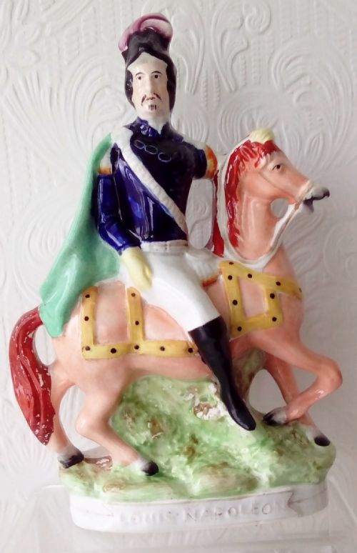 fig 1. A pair of Victorian Staffordshire ceramic equestrian figures depicting Louis Napoleon and the Empress of France mounted on chestnut horses with blue and green details.