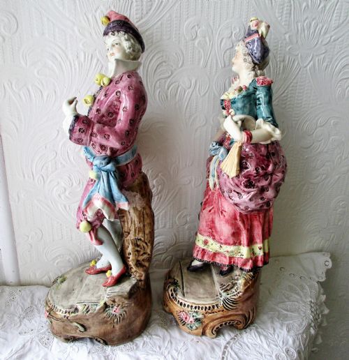 fig 1. A pair of hand-painted French earthenware figurines depicting a male and female figure in carnival attire with rose pink and teal glazes.