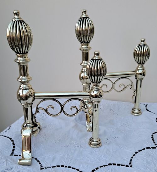 fig 1. A pair of polished Victorian brass andirons featuring fluted spherical finials, baluster turned stems, and splayed legs with scrolled feet.