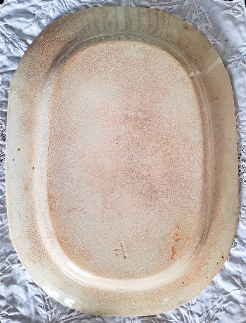 fig 1. An oval Georgian earthenware platter featuring a blue and white underglaze transfer pattern depicting an elephant and oriental architecture framed by a bold floral border.