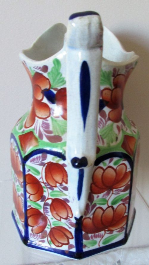 fig 1. An octagonal Victorian Gaudy Welsh ceramic jug decorated with hand-painted rust-orange flowers, green leaves, and cobalt blue borders.