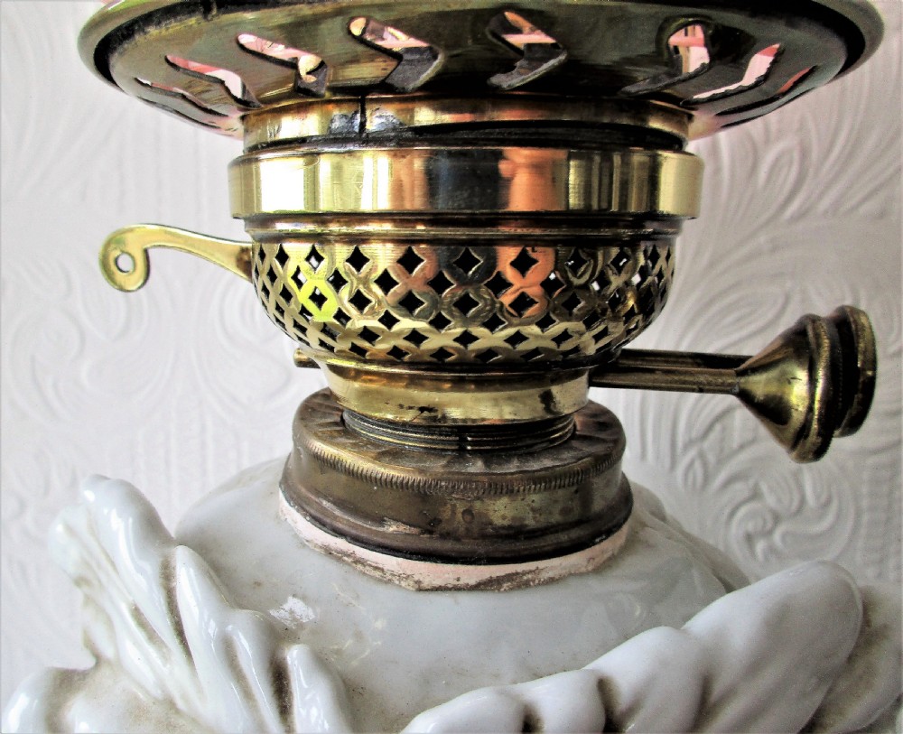 An antique Victorian Sitzendorf oil lamp featuring a sculpted white glazed porcelain owl base with glass eyes, brass burner, clear glass chimney, and a flared, etched pink glass shade. View III
