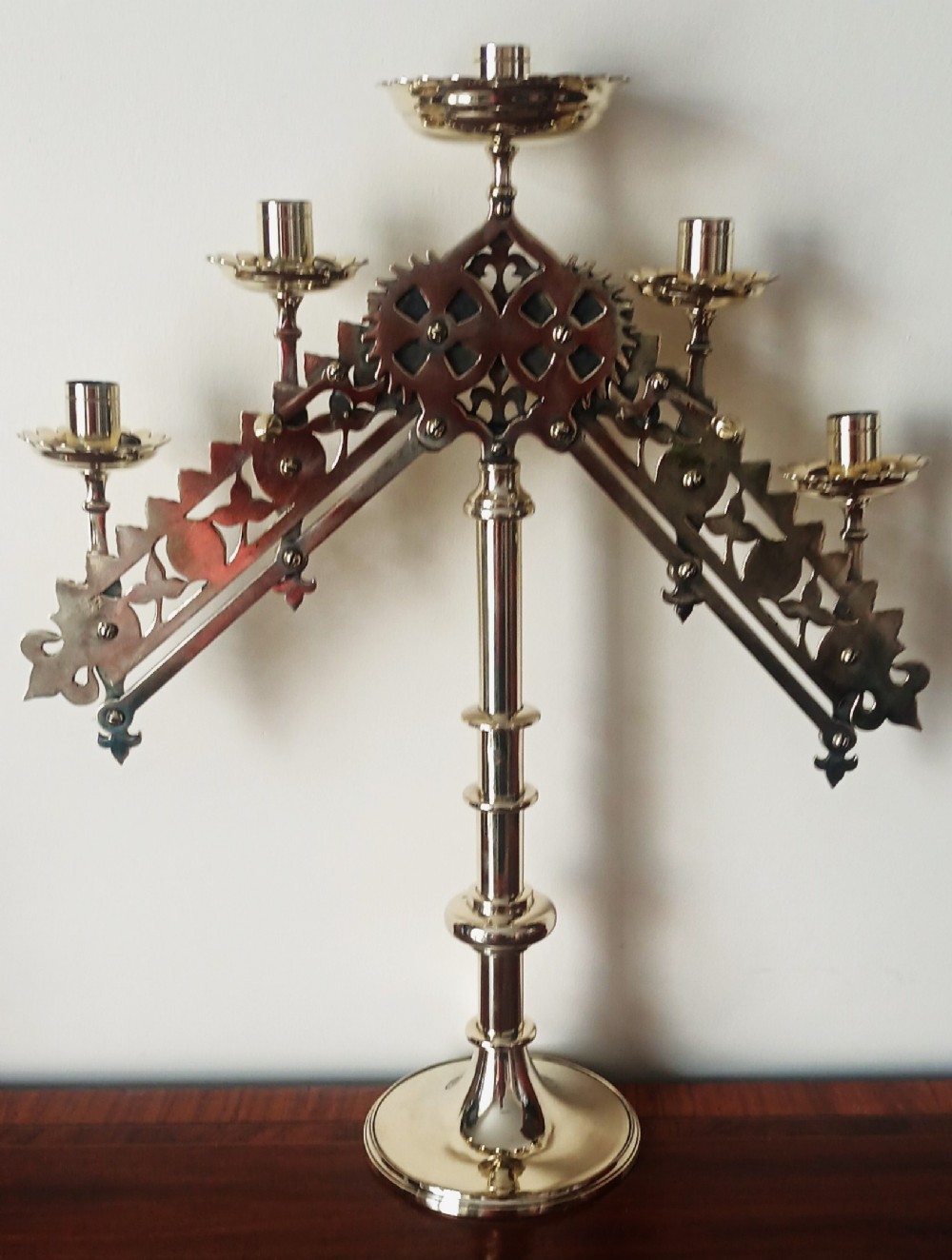 An English Victorian brass five-light articulated candelabra with an adjustable gear mechanism and Gothic pierced arms.