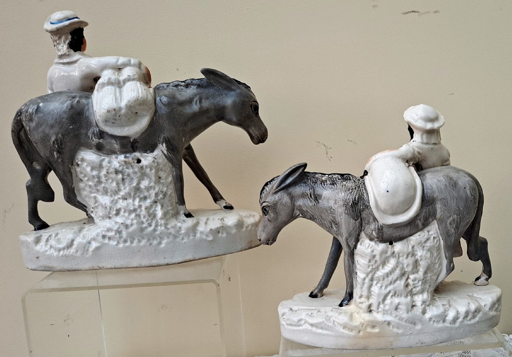 A pair of Victorian Staffordshire earthenware pottery figures depicting street traders named Sand and Beesums standing beside saddled grey donkeys. View XII