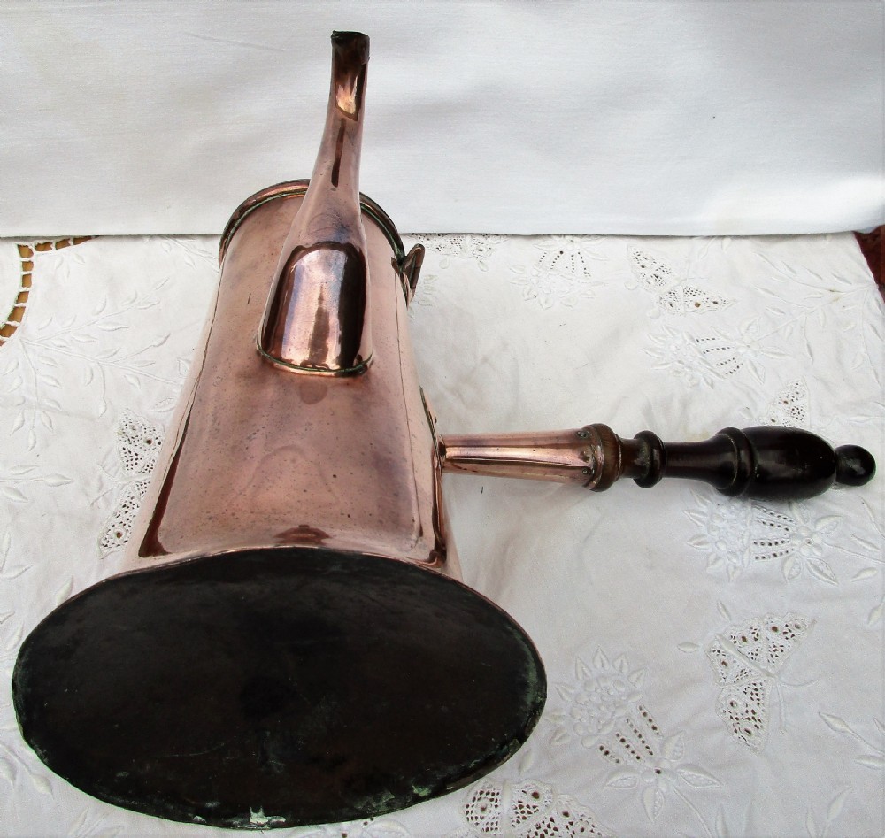 An antique Georgian copper coffee pot with a dark turned wooden side handle, curved spout, hinged lid, and brass finial. View V