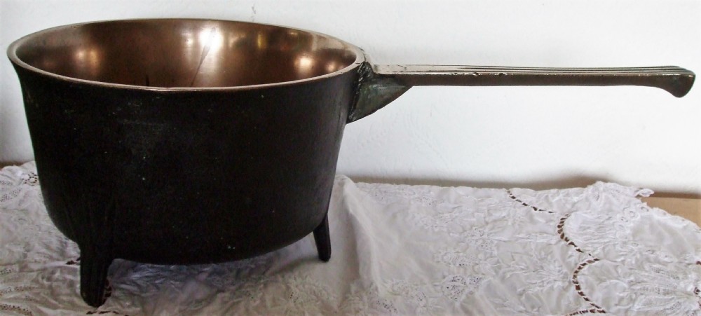 An antique Georgian cast bronze posnet skillet featuring three short legs, a long grooved handle, and a polished interior. View III