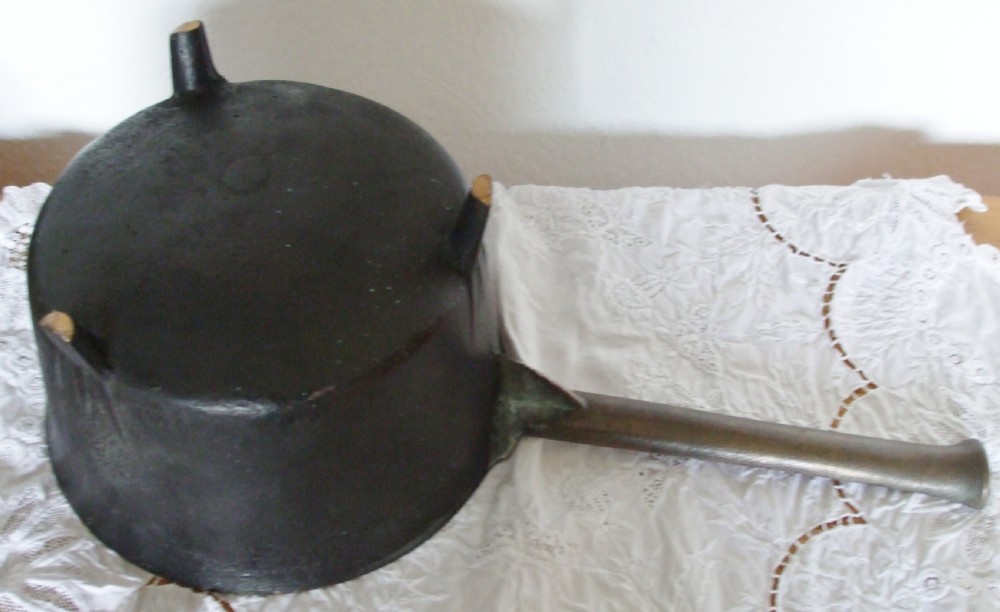 An antique Georgian cast bronze posnet skillet featuring three short legs, a long grooved handle, and a polished interior. View IV