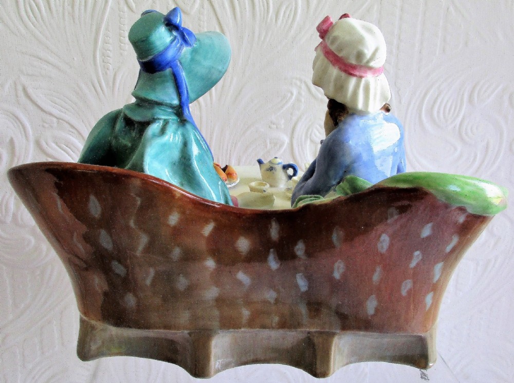 A glazed Royal Doulton porcelain figurine depicting two women in 19th-century attire seated at a tea table. View III