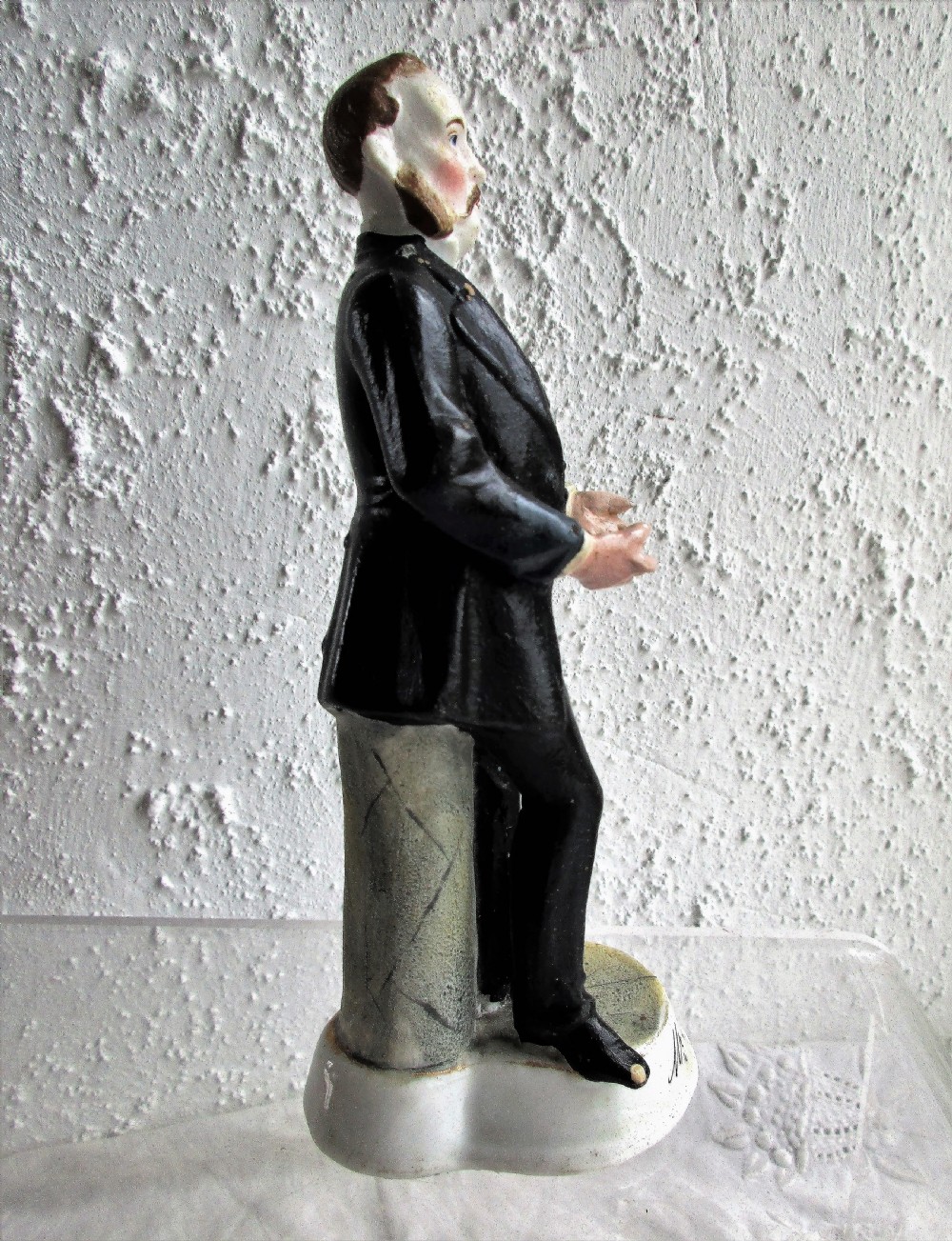 An antique Victorian porcelain figurine depicting a standing man in a black frock coat and bow tie on a round white base inscribed Mr Sankey. View IV