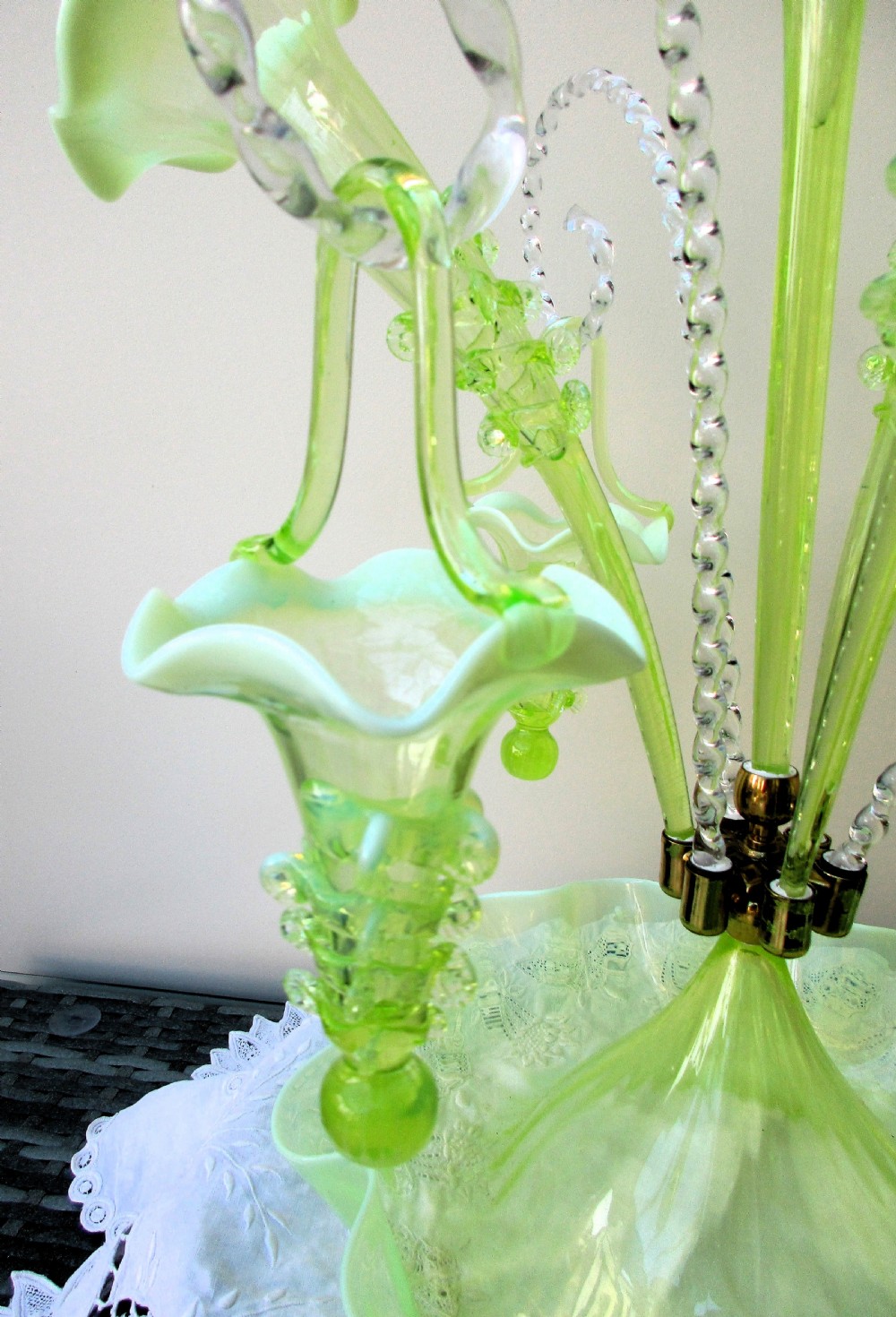 An antique Victorian pale green glass epergne with a tall central trumpet flue, surrounding smaller flues, hanging glass baskets, and a crimped ruffled bowl base. View VI