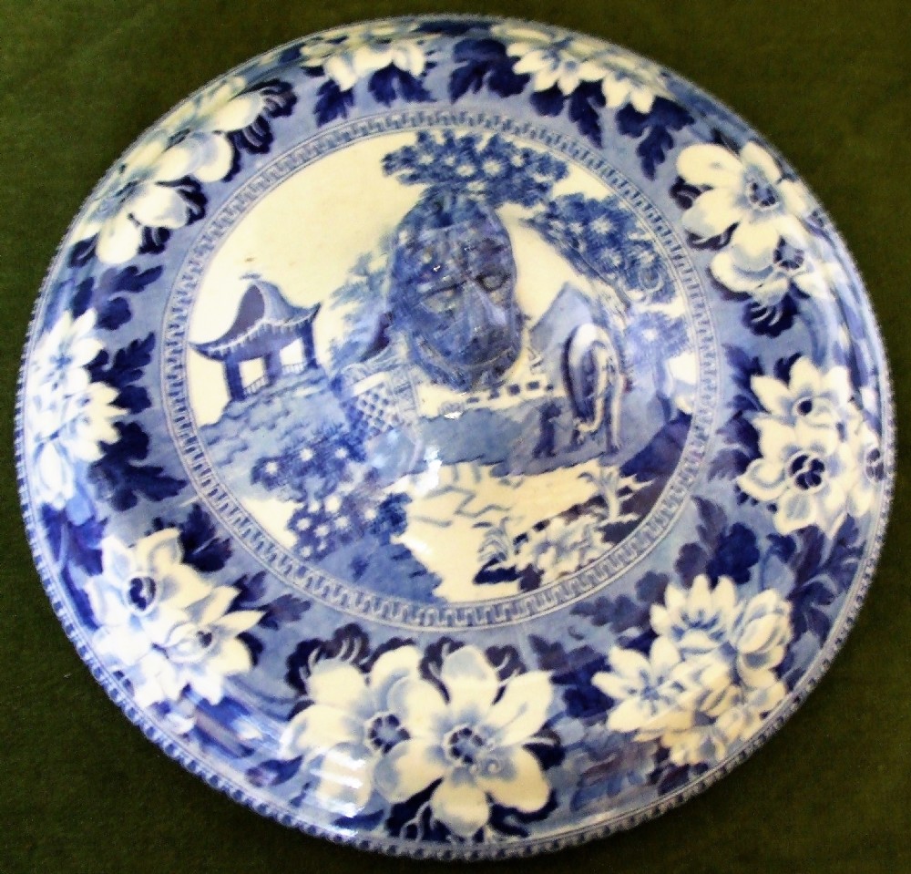 An antique blue and white transfer-printed earthenware tureen featuring a pedestal base, floral patterns, and a fitted lid with a molded animal finial. View II