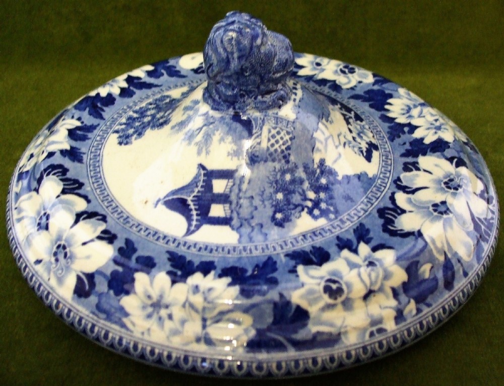An antique blue and white transfer-printed earthenware tureen featuring a pedestal base, floral patterns, and a fitted lid with a molded animal finial. View III