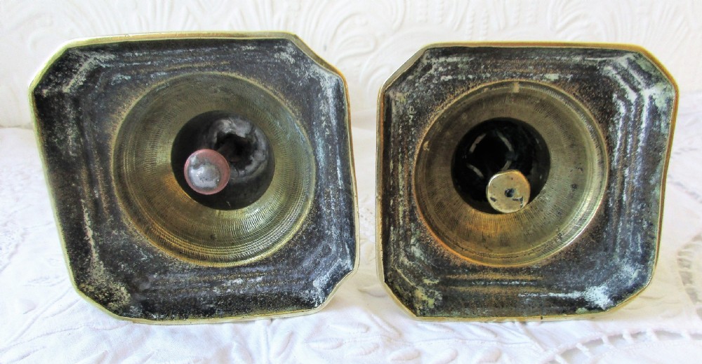 A pair of turned Victorian brass candlesticks featuring baluster stems and square bases. View V